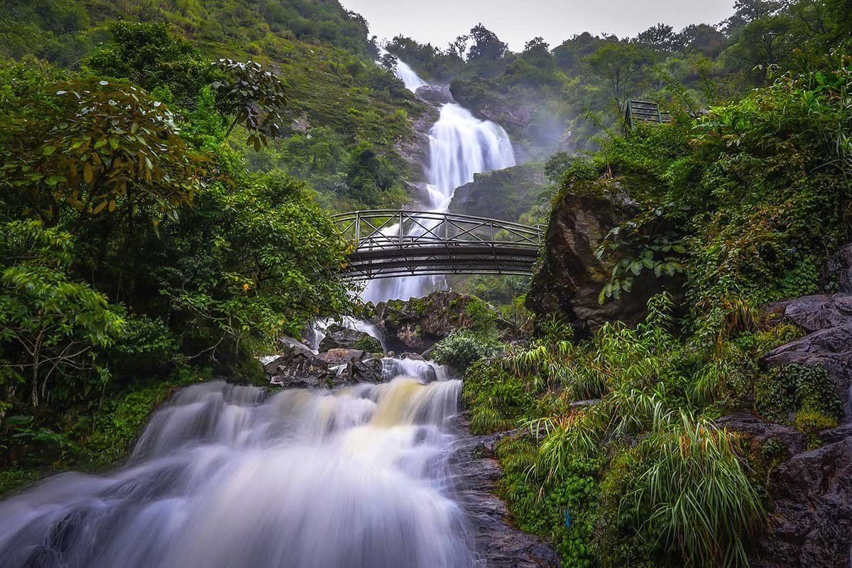 The arched footbridge spanning Silver Waterfall, with the upper tiers of the falls behind.