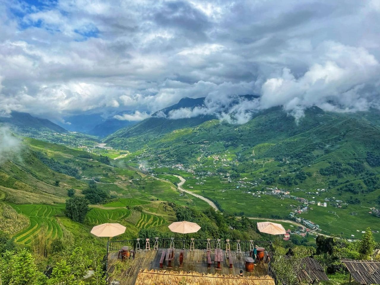 Die Terrasse mit Sonnenschirmen, Blick hinab auf grüne Reisterrassen und das Muong-Hoa-Tal.