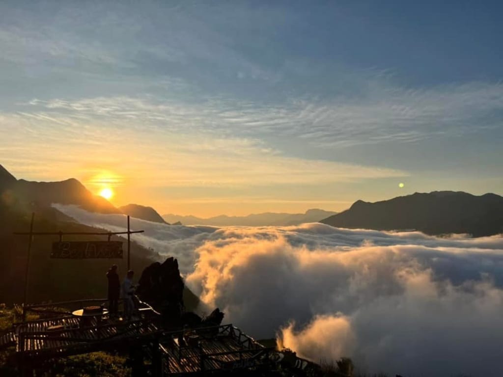 Die Sonne geht über einem Wolkenmeer auf, gesehen vom Deck mit dem Best-View-Schild.