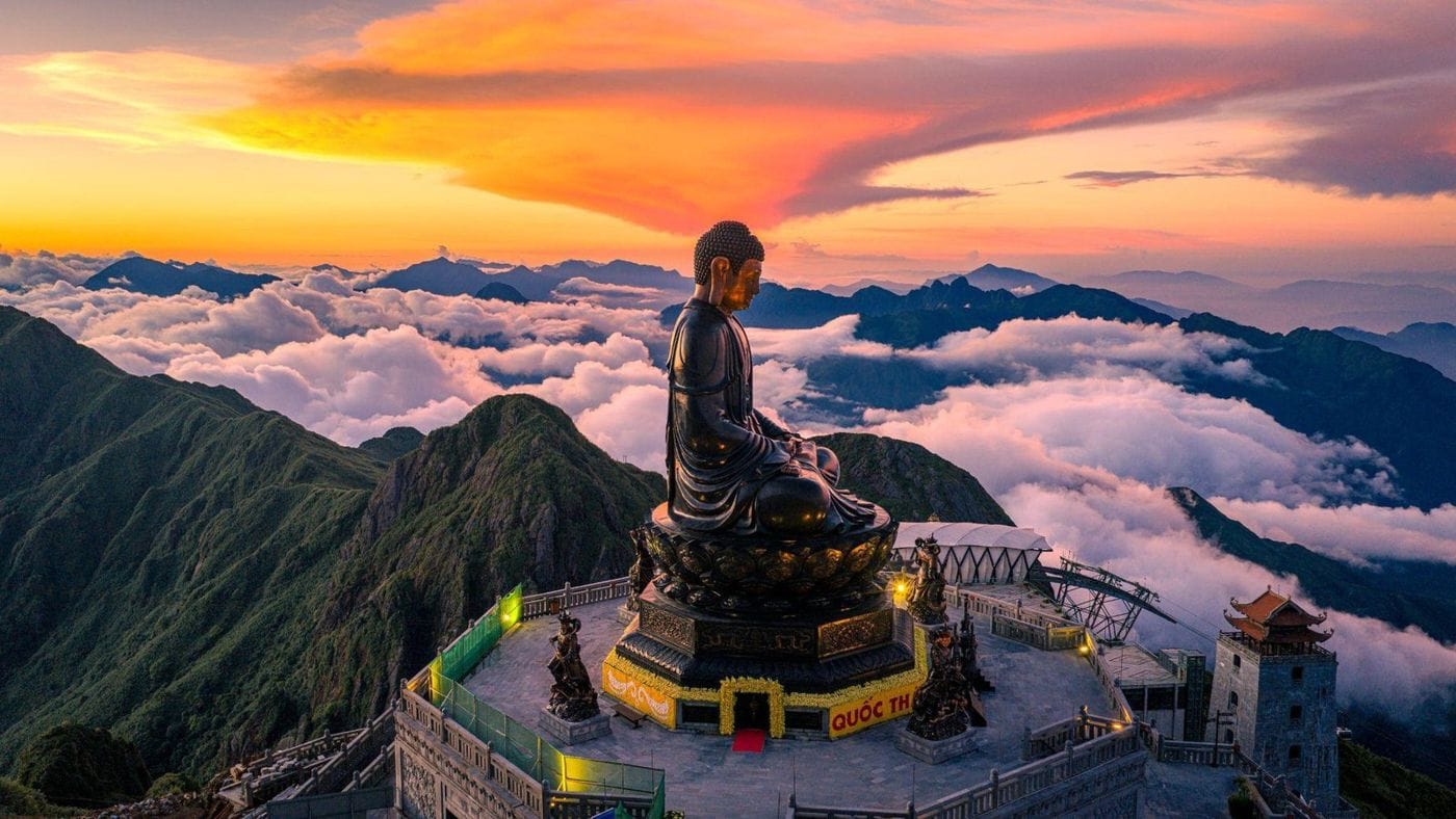 The great Amitabha Buddha statue above a sea of clouds at sunset on Fansipan.