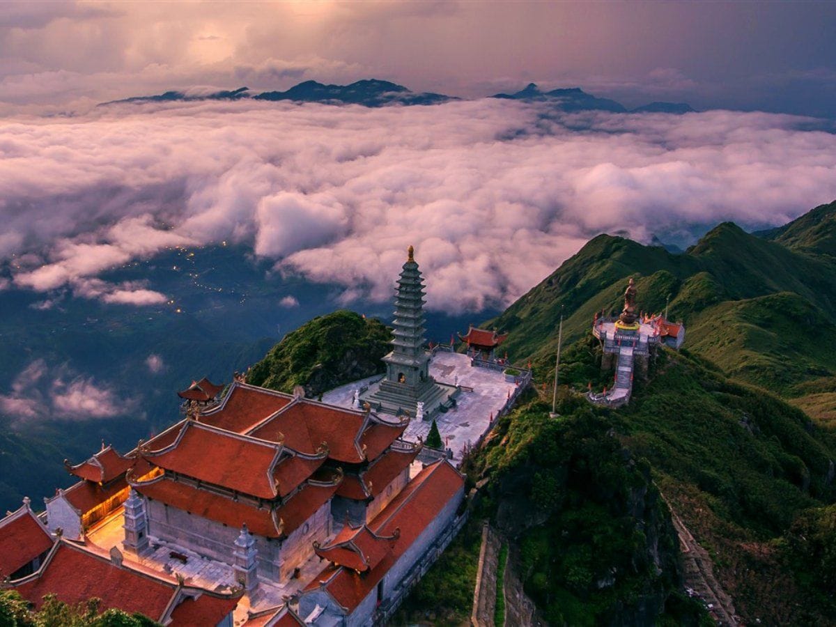 Pagoden und Stupa am Fansipan von oben, dahinter ein Wolkenmeer.