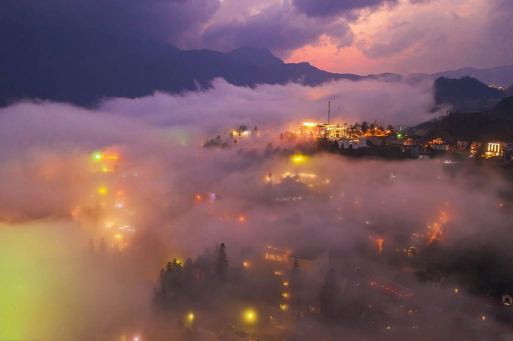 Sapa erleuchtet unter einer Wolkendecke in der Dämmerung.