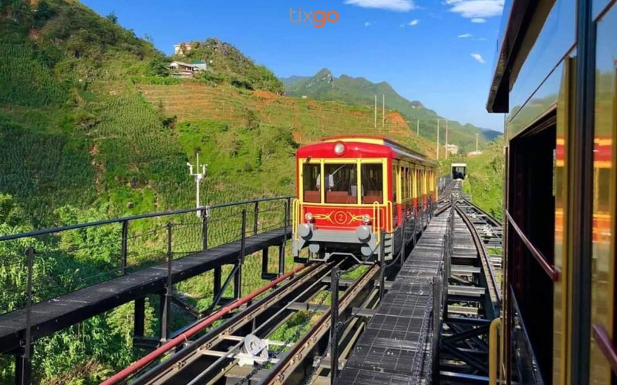 The red-and-yellow train on the track along the Sapa hillside