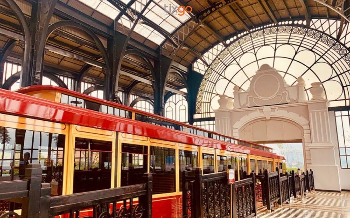 Die gewölbte Glashalle des Bahnhofs mit dem wartenden roten Zug