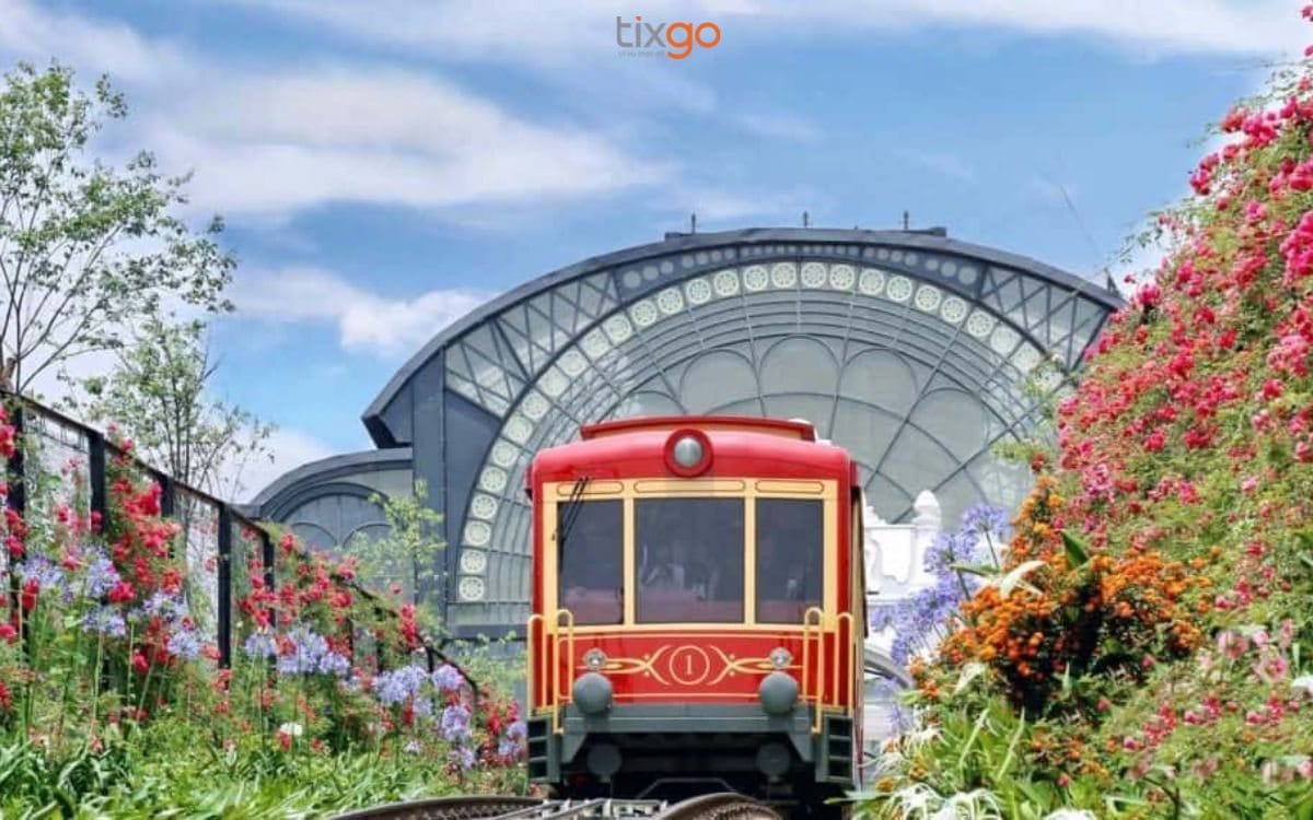 The train arriving at the glass-domed station among flower gardens