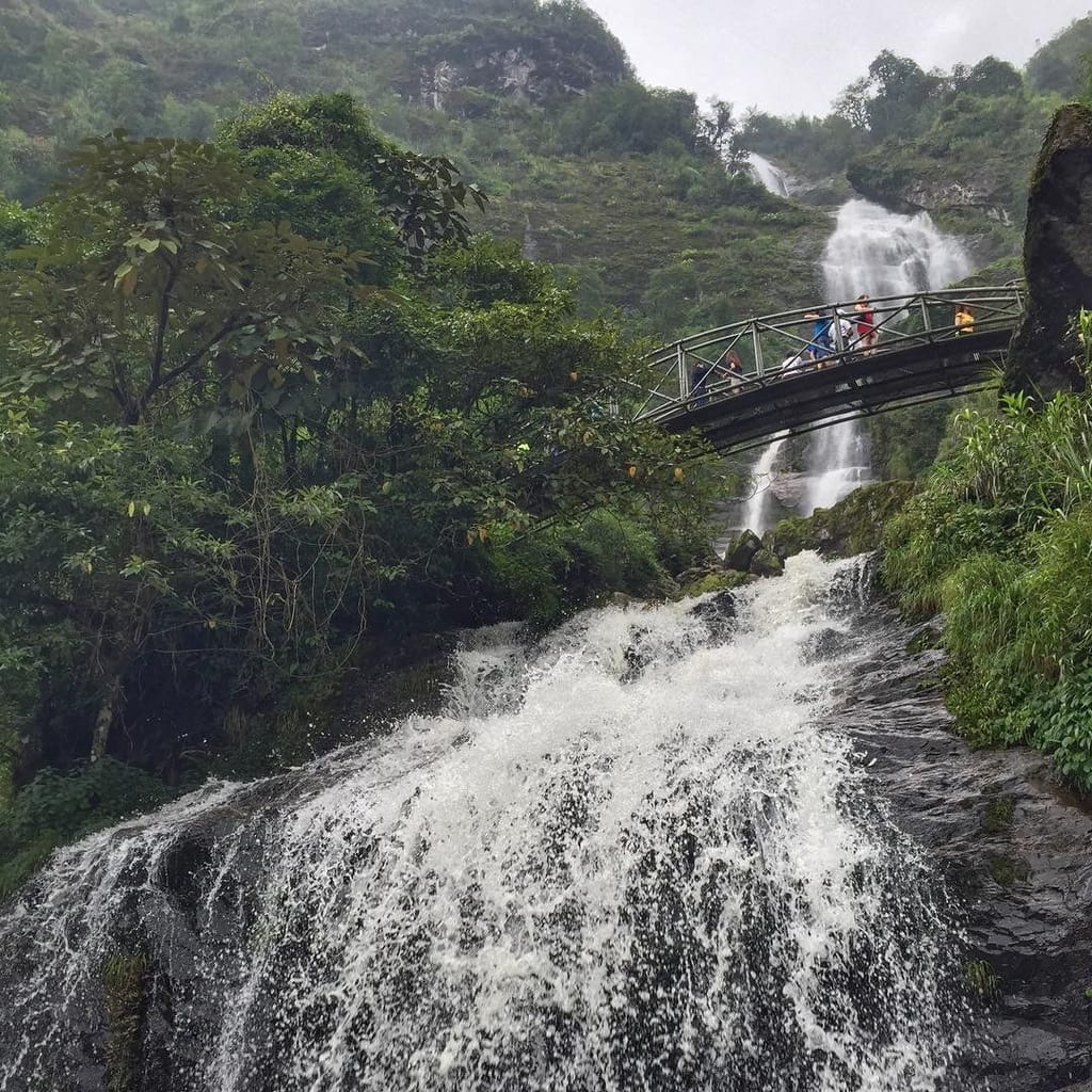 Kräftige Strömung an der unteren Stufe des Silberwasserfalls, oben Besucher auf der Brücke.